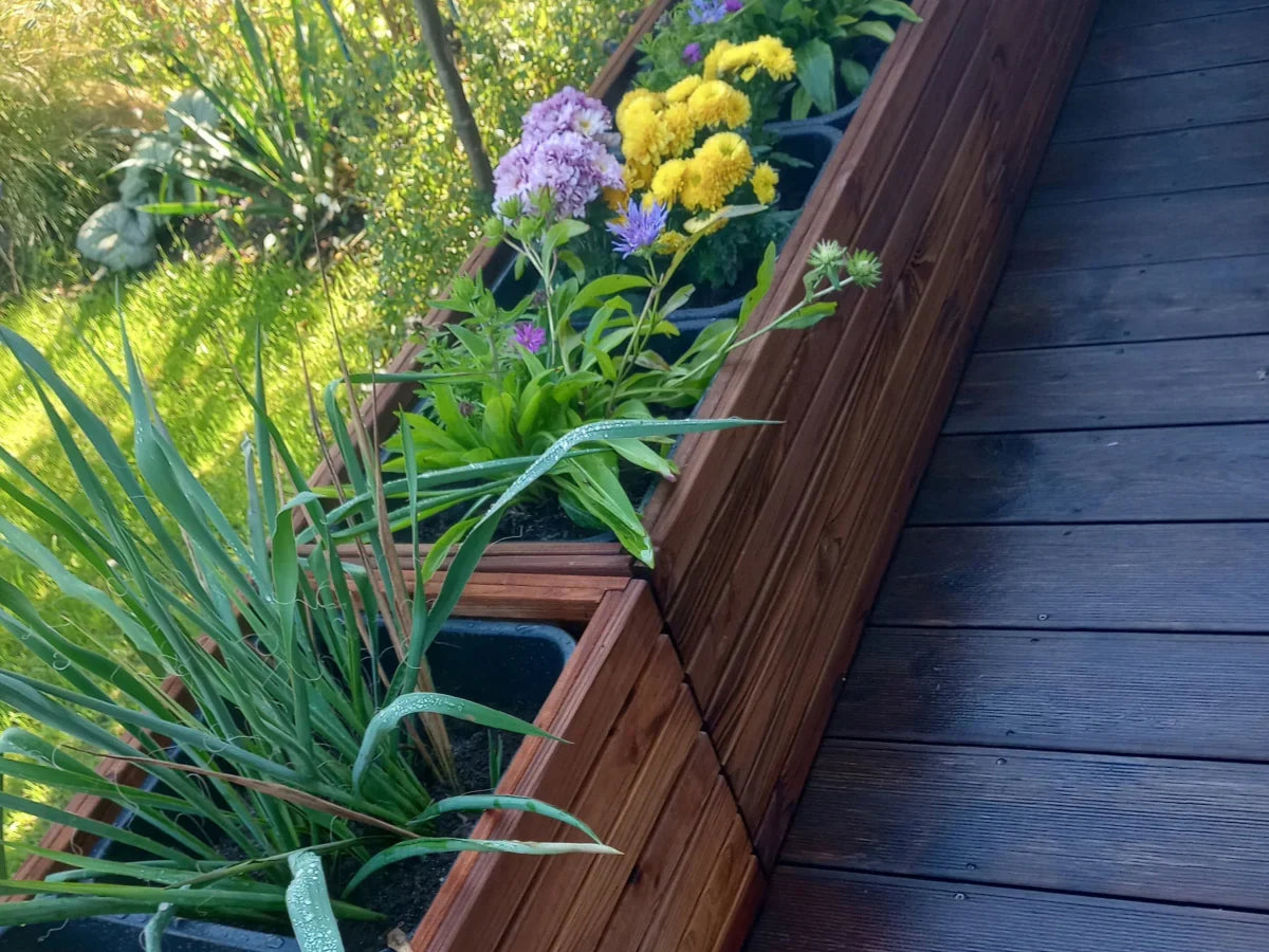 Drewniana donica ogrodowa z kolorowymi kwiatami na tarasie, naturalne materiały