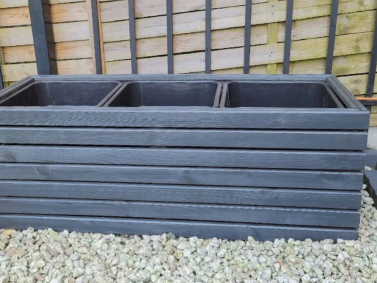 Duża donica z drewna w kolorze antracytowym, trzy wkłady, tło ogrodowe