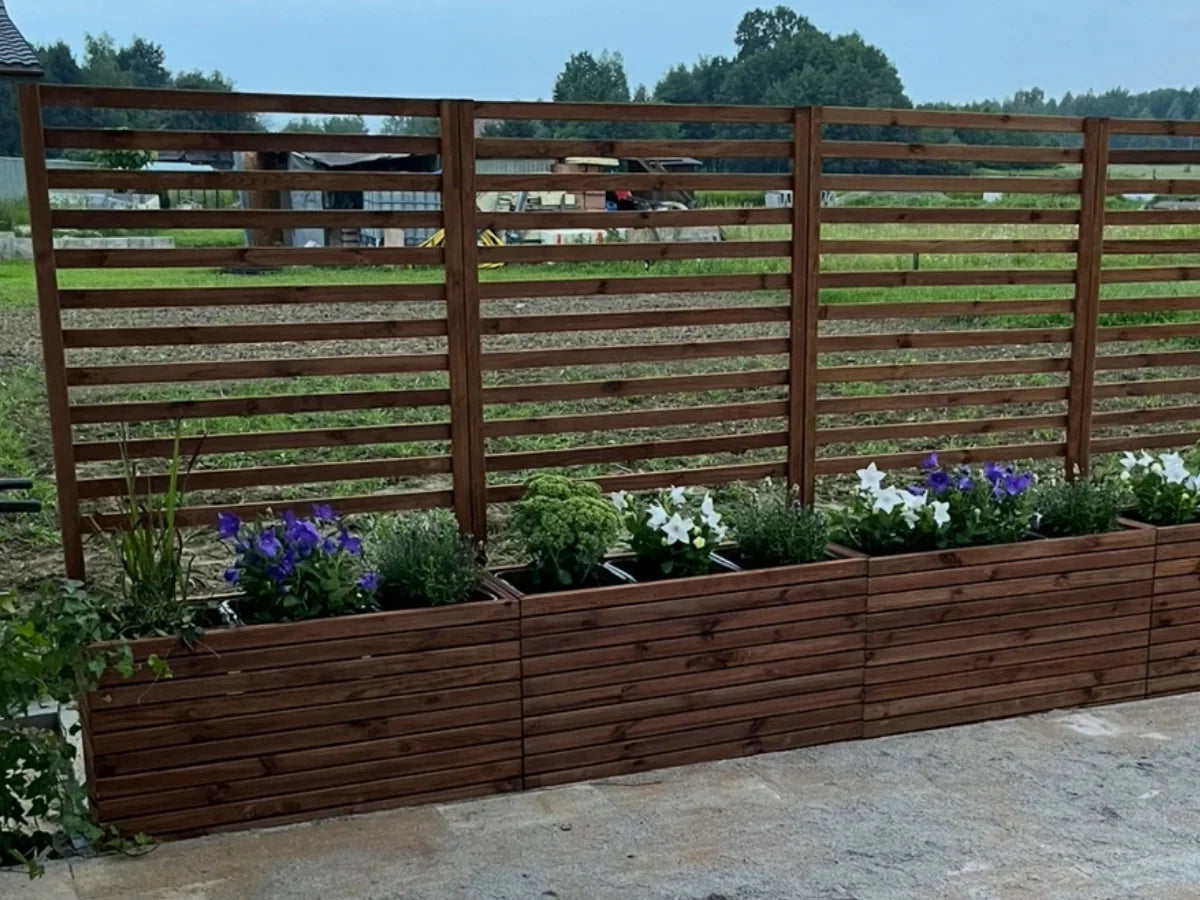 Drewniana pergola ogrodowa z donicami i kwiatami na tle zieleni, nowoczesne ogrodzenie