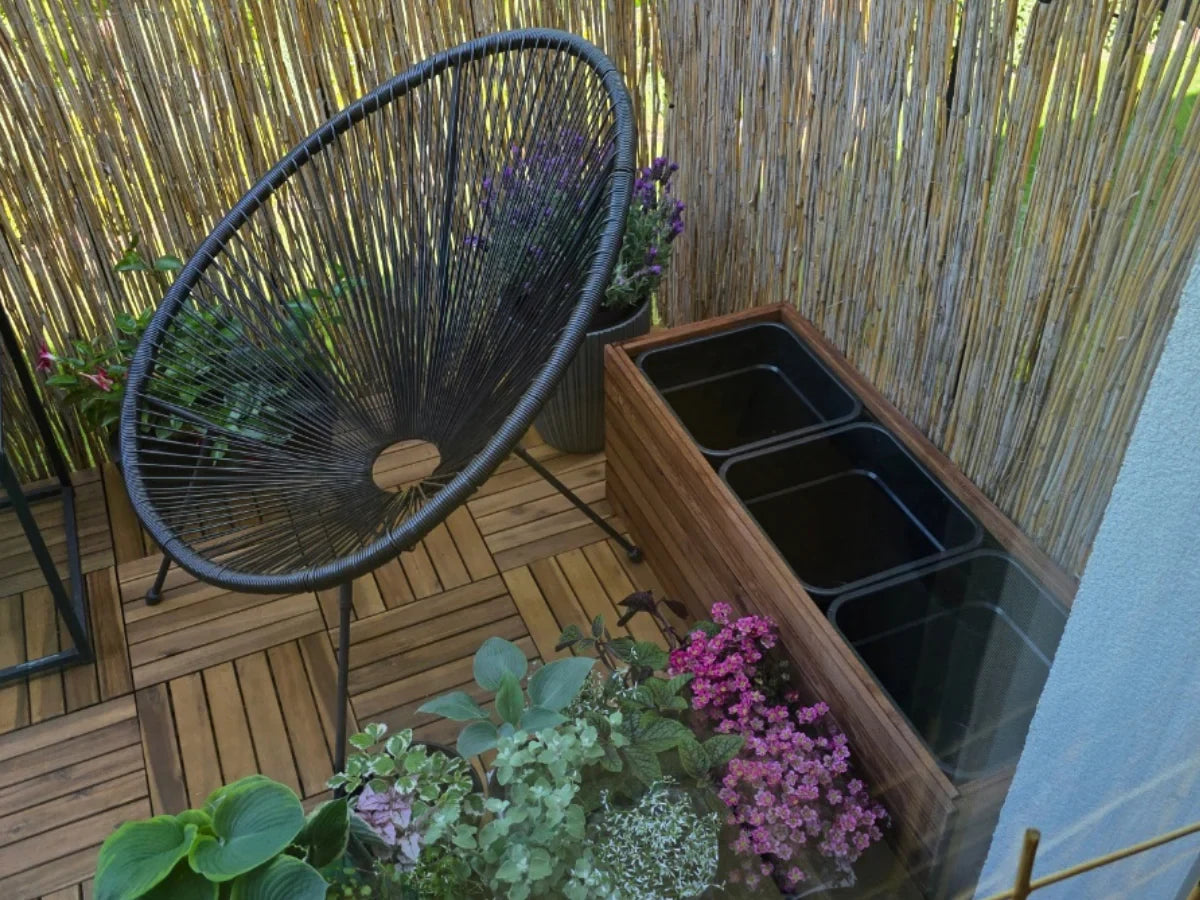 Donica z drewna na balkon, czarne wkłady, rośliny, nowoczesne krzesło, osłona z trzciny